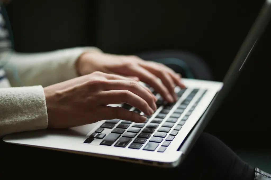 Close-up of hands typing on a laptop keyboard, representing secure digital operations in a cyber environment